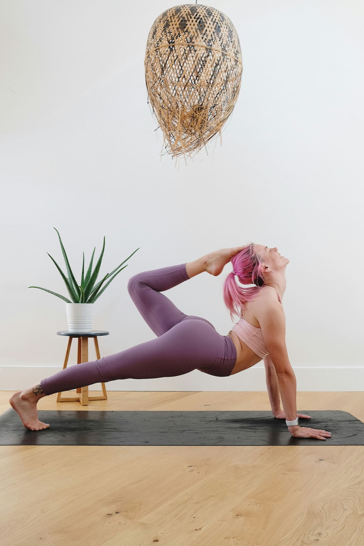 Prof de yoga en posture latérale, ambiance moderne et premium avec mobilier design