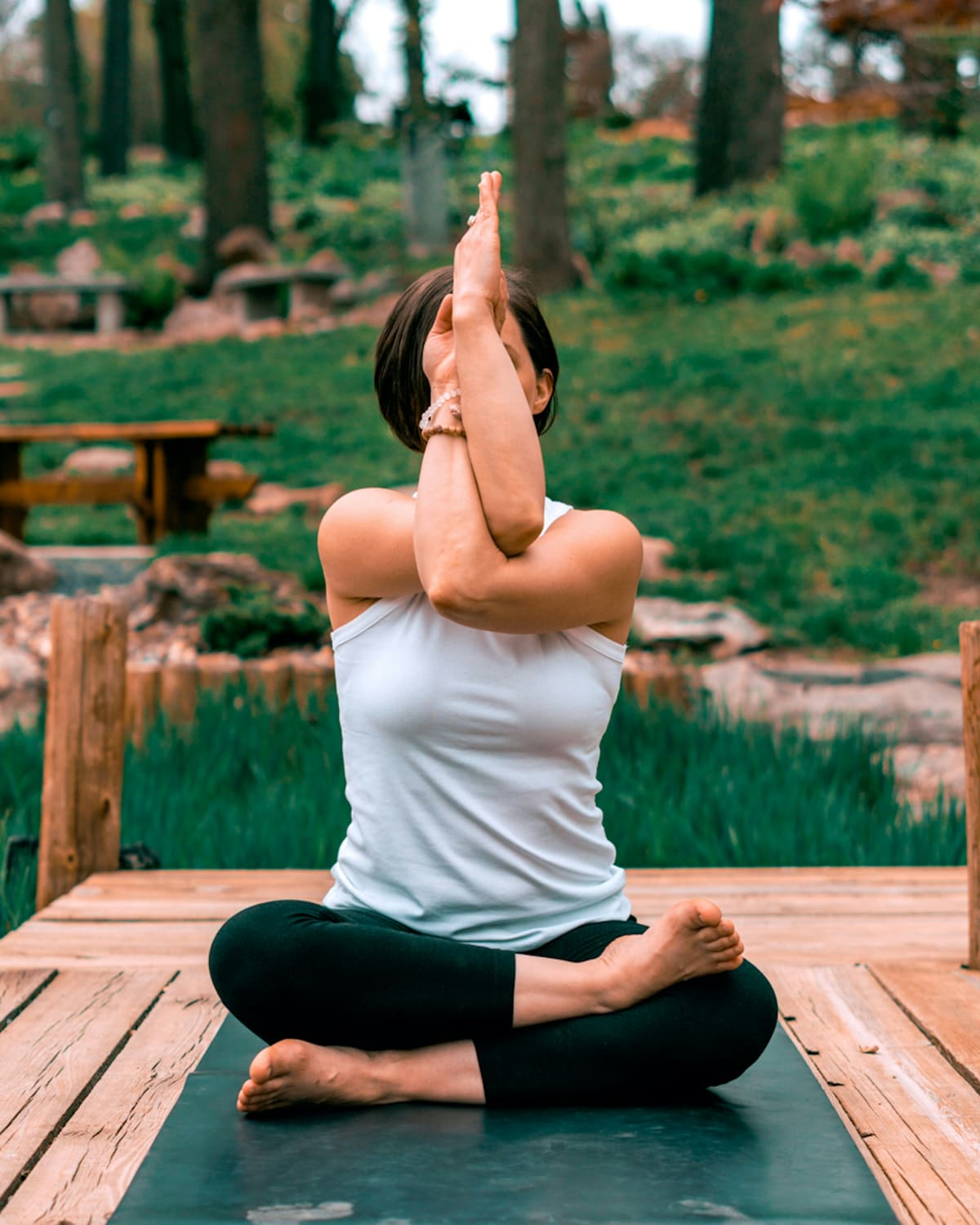 Prof de yoga en posture de l'aigle dans un jardin japonais avec rocaille