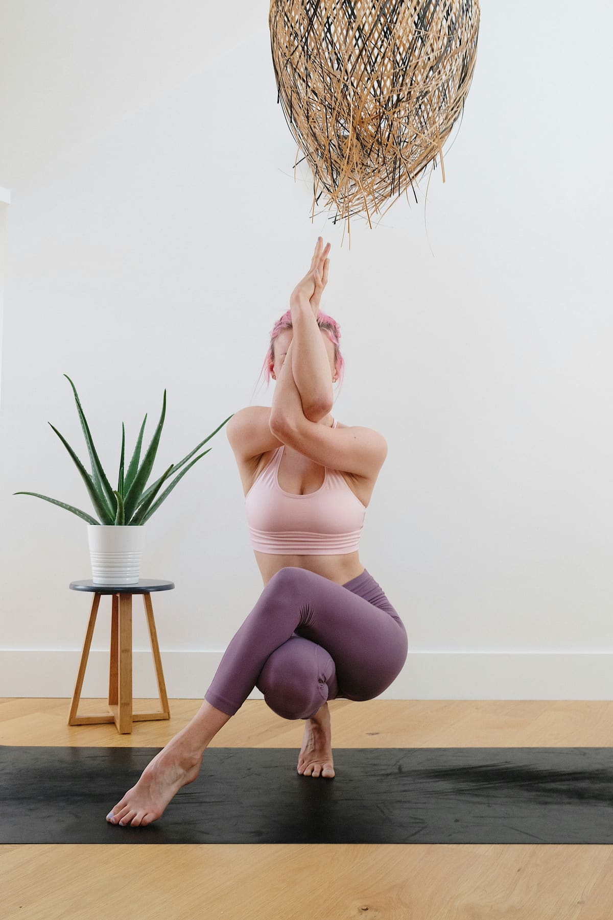 Prof de yoga en posture d'équilibre sur un tapis, ambiance moderne et premium